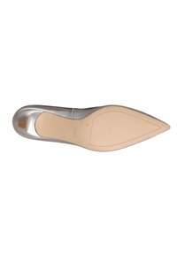 Chaussure plate argentée à bout pointu vue du côté de la semelle, avec une semelle extérieure beige et la marque "hogl" près du talon.