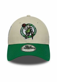 Beige Baseball-Cap mit grünem Schild und gesticktem Boston Celtics-Logo auf der Vorderseite, das eine Figur zeigt, die einen Basketball hält.