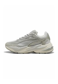 Scarpe da corsa grigio chiaro con un mix di tessuti in rete, suede e pelle. Presentano una suola spessa e balze laterali prominenti.