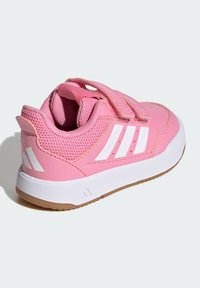 Ružová športová obuv so syntetickým zvrškom, sieťovinovými prvkami, bielymi pruhmi a suchým zipsom. Disponuje gumovou podrážkou pre lepšiu trakciu.