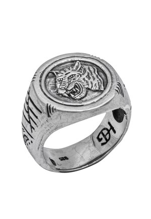 Sterling silver ring featuring a round, raised tiger engraving, textured band with etched lines, and smooth inner surface.