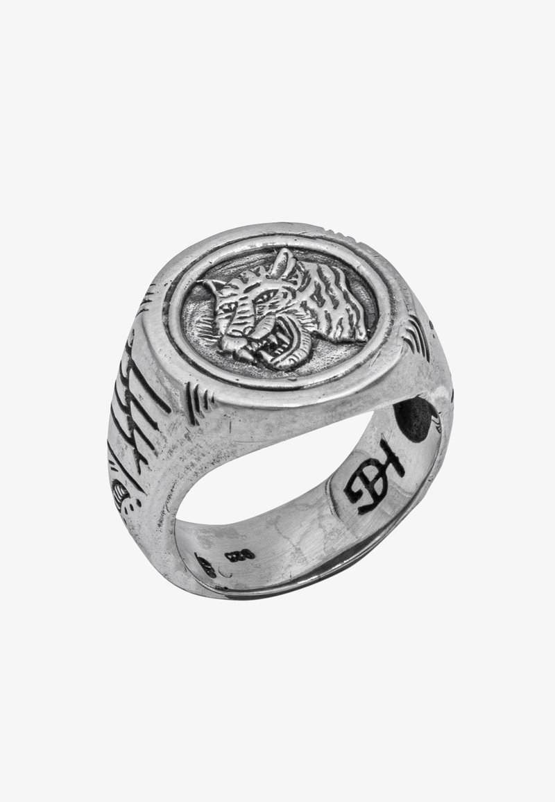 Sterling sudraba gredzens ar apaļu, izcelto tīģera gravējumu, teksturētu joslu ar iegravētām līnijām un gludu iekšpusi.