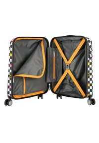 Valigia rigida a scacchi in bianco e nero con accenti arancioni. Dispone di due scomparti, tasca in rete, tasca con zip e cinghie incrociate.