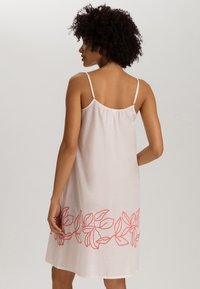 Vestido sin mangas de color rosa claro con corte holgado, que presenta bordados de hojas coral en el dobladillo y tirantes delgados ajustables.