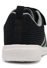 Schwarzer Mesh-Sportschuh mit strukturierter Oberfläche, grauen Akzenten und einer weißen Zwischensohle. Verfügt über eine Schlaufe an der Ferse für ein einfaches Anziehen.