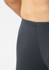 Dark blue athletic leggings with a textured pattern. The waistband is elastic, and there are subtle seams along the sides.