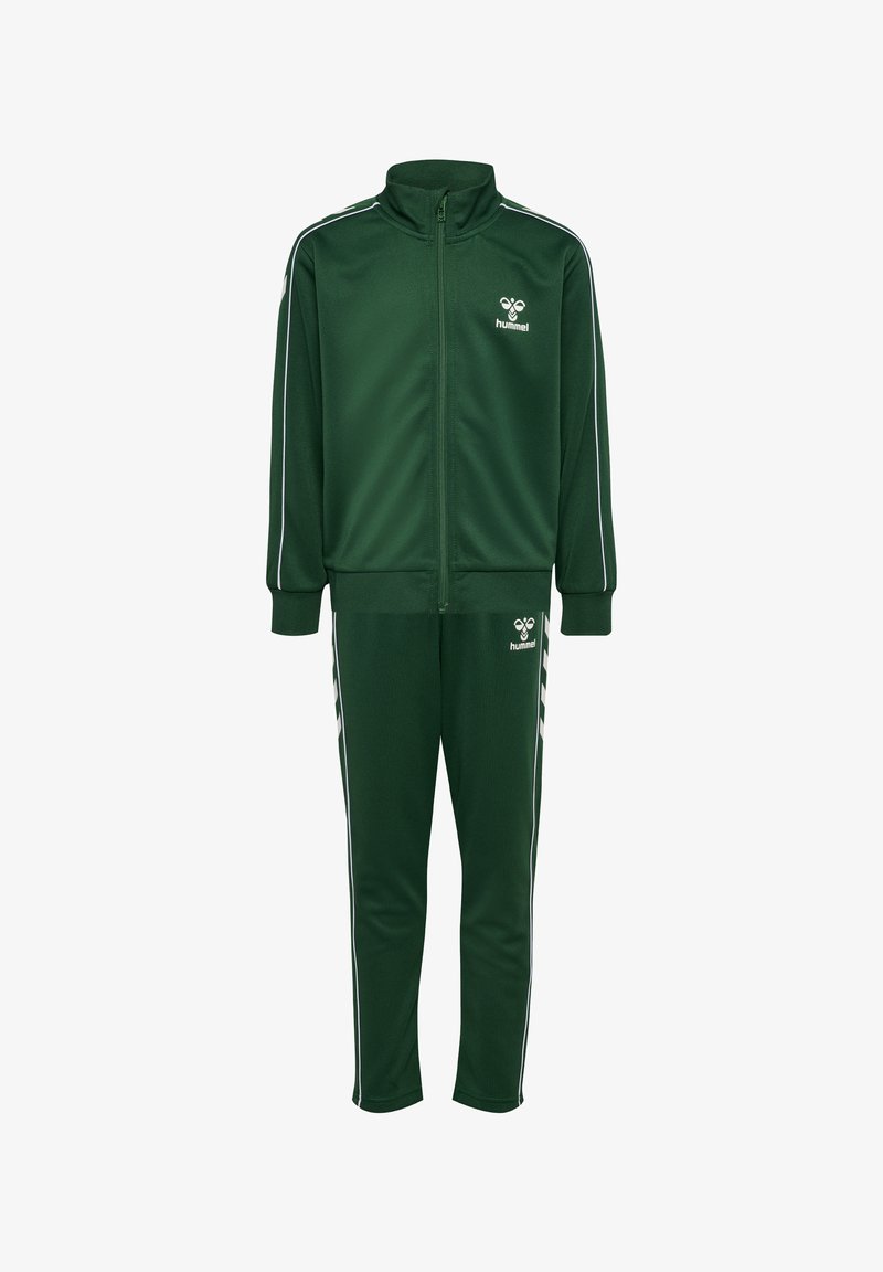 Grüner Trainingsanzug mit einer Reißverschlussjacke mit hohem Kragen und passender Hose, beide mit weißen Paspeln und Logodetails auf der Jacke.