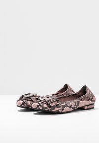 Moccasines de charol en estampado de serpiente rosa con un acabado texturizado, que cuentan con un acento de hebilla plateada en la parte delantera y un tacón bajo y redondeado.