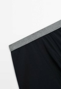Black cotton boxer shorts with a grey elastic waistband, featuring a smooth texture and minimal stitching details near the waistband.