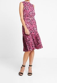 Ärmelloses pinkes Leopardenmuster-Kleid mit taillierter Passform, plissiertem Rock und einem Gürtel in der Taille. Verfügt über glattes Material und eine ausgestellte Silhouette.