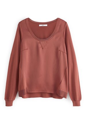 Pull-over manches longues couleur rose poussiére, avec encolure dégagée, poignets côtelés et ourlet légèrement plus long à l'arrière, confectionné en panneaux de tissus mélangés pour une coupe décontractée.
