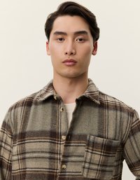 Πουκάμισο από μάλλινη καρώ ύφανση με καφέ, μπεζ και γκρί αποχρώσεις, κλασικό γιακά, κούμπωμα με κουμπιά και τσέπη στο στήθος. Μαλακή υφή και ίσια γραμμή.