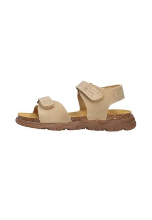 Beige adjustable strap sandal with cork footbed and textured brown rubber sole, designed for comfort and casual wear.
