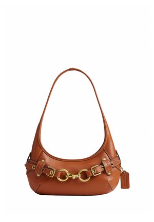 Sac d’épaule en cuir marron avec boucles et anneaux dorés, forme arrondie et petite étiquette en cuir attachée sur le côté.