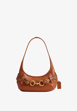 Sac d’épaule en cuir marron avec boucles et anneaux dorés, forme arrondie et petite étiquette en cuir attachée sur le côté.