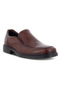 Zapato marrón de cuero sin cordones con paneles laterales elásticos, punta redonda y una suela negra de goma resistente. Presenta detalles de costura sutiles.