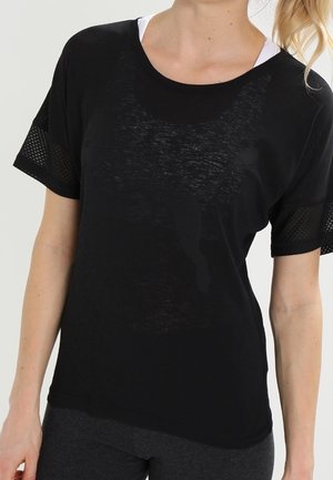 Camiseta deportiva negra con un corte relajado, que presenta mangas de malla, un cuello redondeado y una textura ligera. Ideal para ropa de actividad.