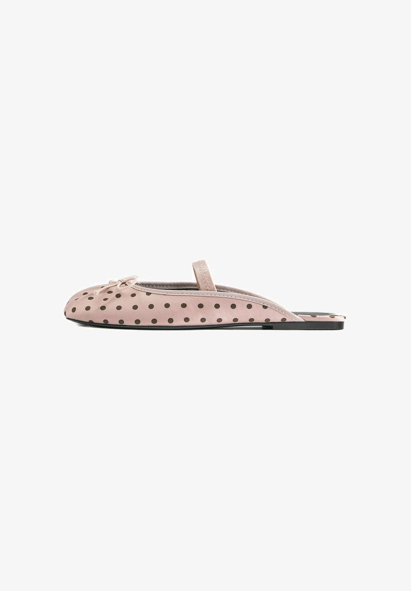Flat pink slip-on shoe with black polka dots, a thin strap across the top, and a small bow near the toe.