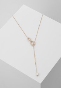 Colar de ouro rosa com um pingente em forma de símbolo do infinito, adornado com pequenas cristais, apresenta um encantador coração pendurado na extremidade da corrente.
