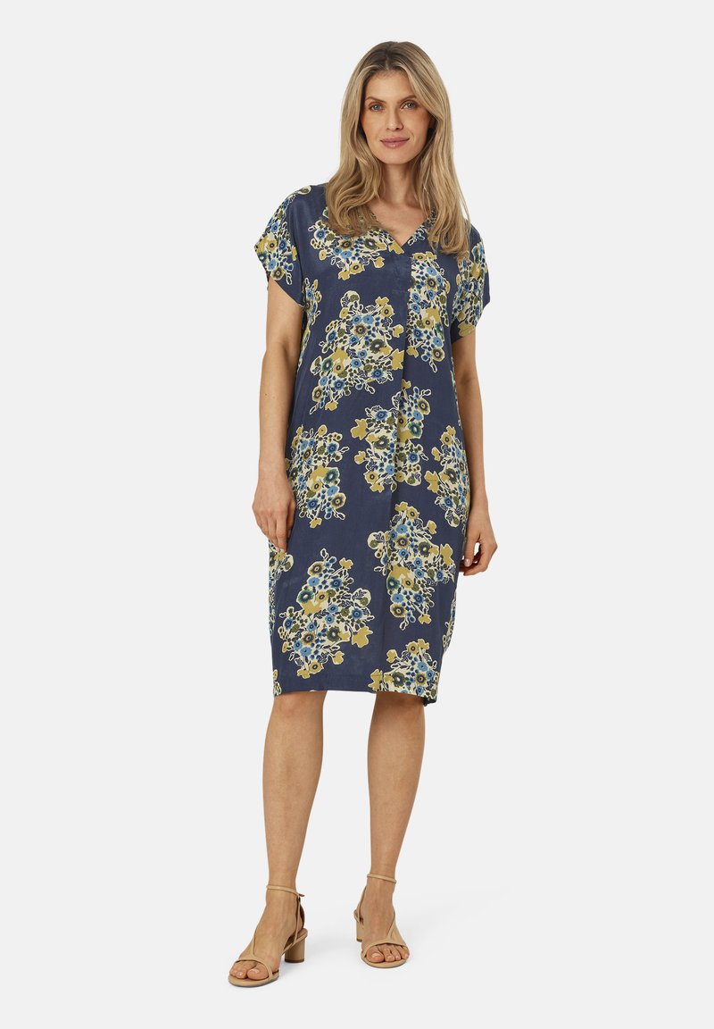 Robe marine avec un motif floral en jaune et bleu. Décolleté en V, manches courtes, longueur genoux, fabriquée en tissu léger. Design minimaliste.