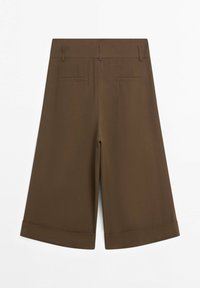 Pantalon marron à jambes larges et coupé, avec passants de ceinture et deux poches passepoilées à l'arrière, présenté à plat sur fond blanc.