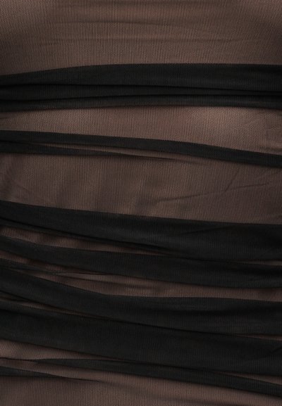 Μαύρο διαφανές ύφασμα σε οριζόντια πτυχώσεις πάνω σε μπεζ φόντο, δημιουργώντας ένα υφασμάτινο ημιδιαφανές ριγωτό μοτίβο.