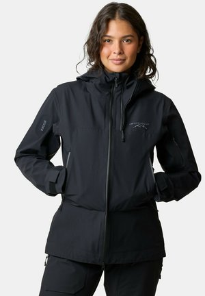 Giacca nera impermeabile con cappuccio, zip frontale e multiple tasche con zip. Presenta un logo sul petto e polsini regolabili.