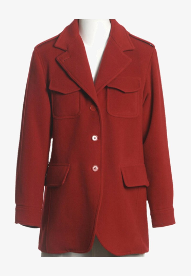 Manteau en laine rouge avec larges revers, quatre poches à rabat, manches longues et trois boutons devant sur un mannequin sans tête.