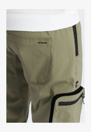 Pantaloni cargo khaki con una tasca posteriore con logo "ombre", accenti neri sulla tasca laterale e sulla cerniera, e un tessuto testurizzato.