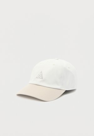 Casquette de baseball blanche et beige avec un petit logo triangulaire comportant les lettres "a c c" sur le panneau avant.