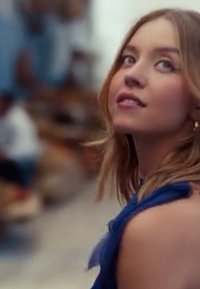 Giovane donna con lunghi capelli mossi che indossa un top senza maniche di un blu profondo. Una luce morbida mette in risalto i suoi tratti e lo sfondo.
