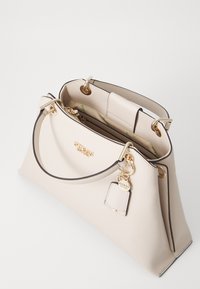 Borsa per il tempo libero in finta pelle beige con una forma strutturata, dettagli in metallo dorato e un portachiavi removibile. Presenta un ampio interno con numerose tasche.