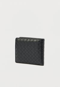 Μαύρο δερμάτινο πορτοφόλι με υφή πλεξίματος, ορθογώνιο σχήμα και αντίθετες ραφές. Διαθέτει λεπτό σχεδιασμό και λεία επιφάνεια.