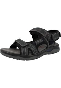 Black sandal with adjustable velcro straps, padded footbed, and textured rubber sole. Features contrasting white stitching and a sporty design.