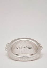 Anello in metallo argentato con un design liscio e arrotondato. Presenta due piccoli dettagli sporgenti e la scritta "Massimo Dutti" incisa all'interno.