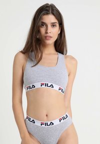 Grå sport-bh och trosor med Fila-logotyp på bandet. Materialet är mjukt, med en sömlös design och en tajt passform för komfort.