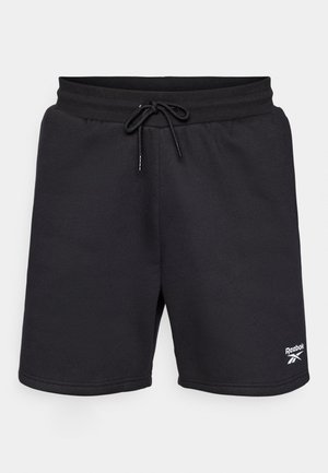 Crne dukserice s elastičnim pojasom i vezicom. Sadrži bijeli Reebok logo na donjoj desnoj nozi. Meko, teksturirano tkanje.