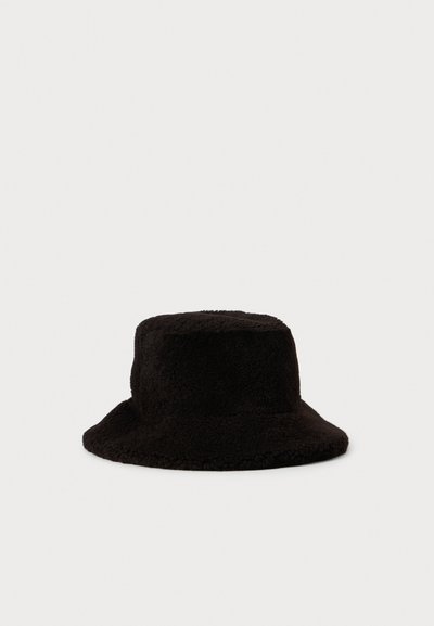 Zwarte fuzzy emmerenhoed met een brede rand en een zachte, gestructureerde stof, tegen een effen witte achtergrond.