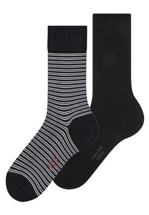 Paire de chaussettes mi-mollet, une entièrement noire et l'autre noire à rayures horizontales blanches, toutes deux avec le texte de la marque près de l'avant-pied.