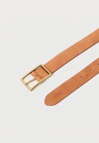 Ceinture en cuir havane avec boucle rectangulaire en laiton et cinq trous de réglage, posée à plat sur un fond blanc.