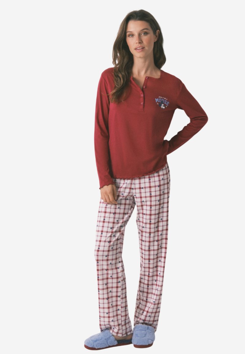 Punainen pitkähiha pyjama paita napilla kauluksessa ja logolla. Valkoiset ruudulliset pyjamahousut pienillä sinisillä yksityiskohdilla; pehmeät siniset tossut.