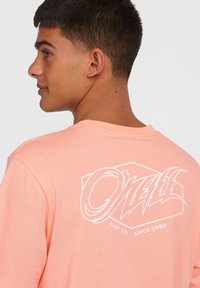 Peach cotton t-shirt with short sleeves, featuring a white graphic logo on the back that includes "O'Neill Surf Co. Since 1952."