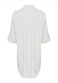 Lightly striped button-up shirt in soft fabric. Features a back pleat, rolled short sleeves, and a curved hem, primarily white with pale blue lines.