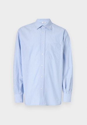 Jasnoniebieska, w paski, długorękawowa koszula z kołnierzykiem zapinanym na guziki, pojedynczą kieszenią na piersi oraz zapięciem na guziki. Wykonana z gładkiej, tkanej tkaniny.