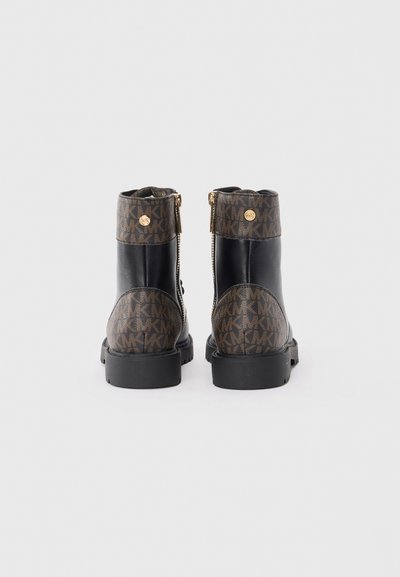 Bottines en cuir noir avec un dessus brun à motifs, dotées d'une fermeture éclair dorée, d'un bout rond et d'une semelle en caoutchouc texturée.