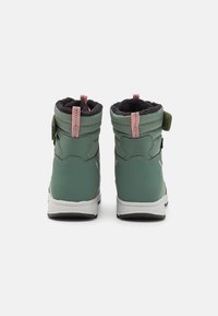 Groene waterdichte laarzen met een gequilt ontwerp, zwarte zachte voering, roze accenten en een verstelbare strap bij de enkel. Witte rubberen zool.