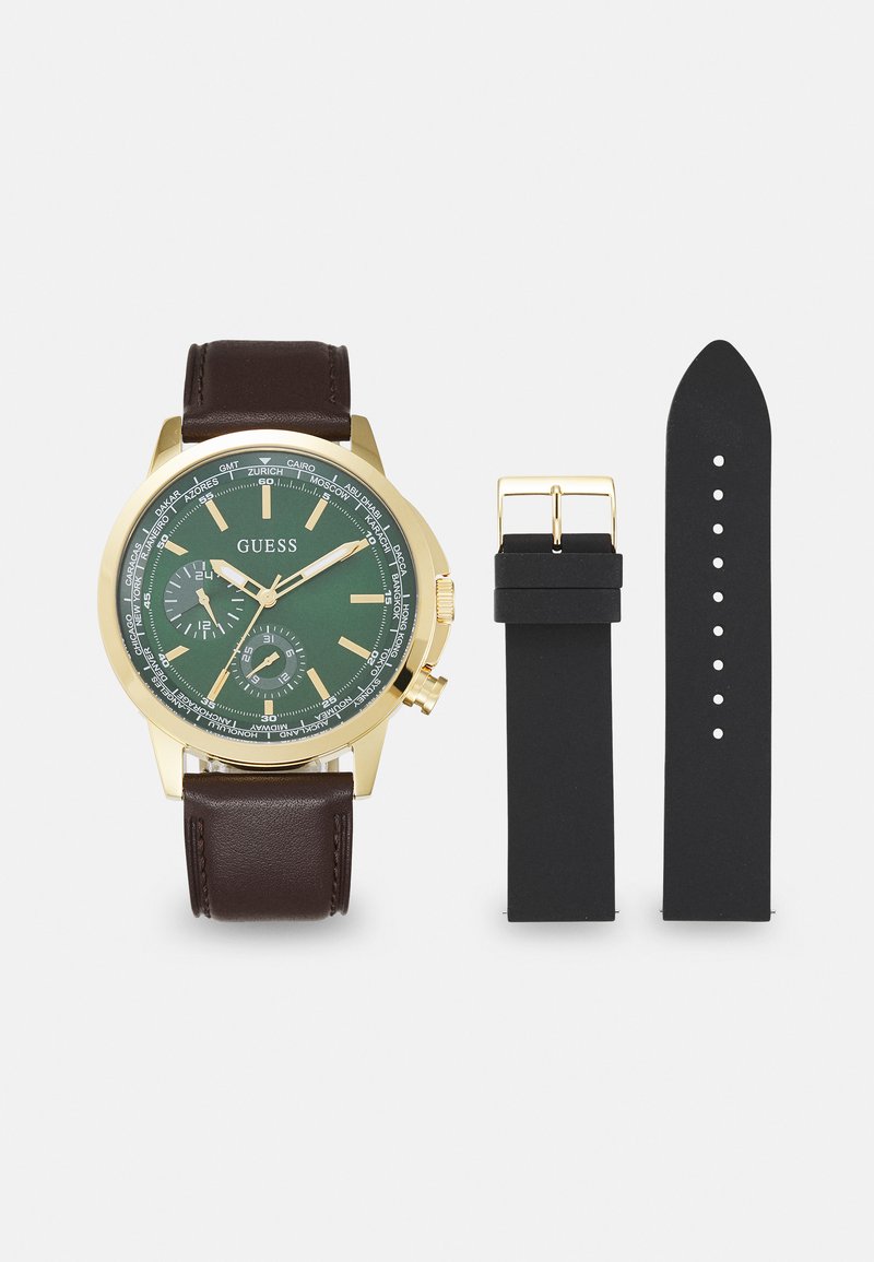 Orologio dorato con quadrante verde, cinturino in pelle marrone e cinturino in silicone nero incluso. Molti quadranti secondari e città incise sulla lunetta.