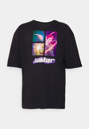 T-shirt noir avec des panneaux graphiques colorés sur le thème de l’espace et le mot "solar" en texte blanc et violet en gras en dessous.