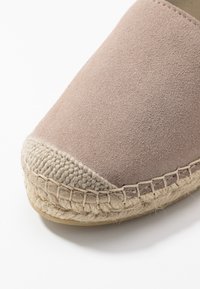 Espadryle w miękkim różowym zamszu z okrągłym noskiem i naturalną podeszwą z jutowego sznurka. Posiadają kontrastowe szwy i fakturowane wykończenie.