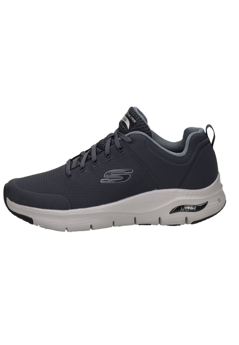 Zapatilla deportiva con una parte superior de malla gris, detalles en gris claro y una suela blanca. Cuenta con un acolchado en el cuello y una lengüeta trasera para ponerlas fácilmente.